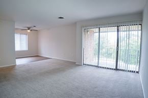 Dayton apartment for rent - A spacious room with a carpeted floor and sliding glass doors.