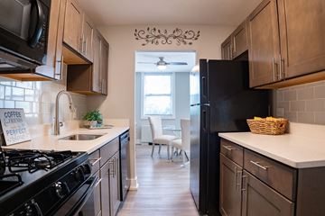 Dayton apartment for rent - A kitchen with a black refrigerator and a sign that says "coffee caramel perfect.".