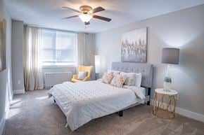 Dayton apartment for rent - A bedroom with a bed, a chair, and a painting on the wall.