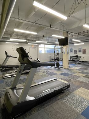 Dayton apartment for rent - A treadmill in St. Clair Lofts fitness center with bright overhead lighting