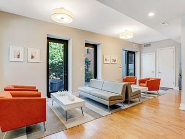 Cincinnati apartment for rent - A living room with a white couch and orange chairs.