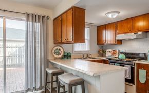Riverside apartment for rent - Model unit kitchen with an island and two stools.