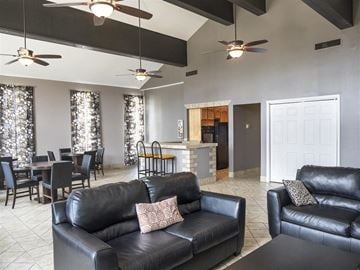 Riverside apartment for rent - a living room and dining room with leather couches and a table