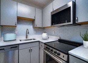 Riverside apartment for rent - Model unit kitchen with stove and microwave.