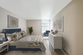 Lauderhill apartment for rent - A bedroom with a large bed and a blue headboard.