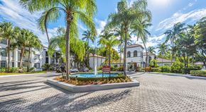 Miami apartment for rent - A sunny day at a residential area with a pool and palm trees.