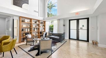 Miami apartment for rent - A living room with a yellow chair and a black couch.