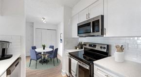 Miami apartment for rent - A modern kitchen with a table and chairs.