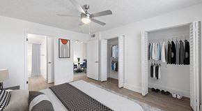 Miami apartment for rent - A bedroom with a bed, a chair, a wardrobe, and a ceiling fan.