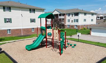Parma Heights apartment for rent - A playground with a green slide and red and green play structure.