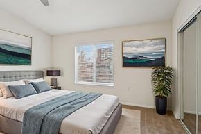 Willoughby Hills apartment for rent - A bedroom with a large bed and a painting on the wall.