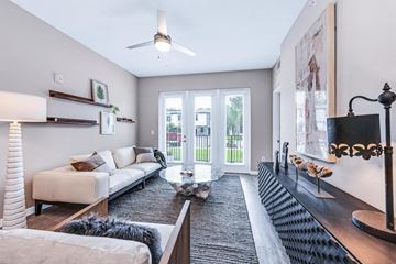 Fort Myers apartment for rent - A living room with a white couch, a coffee table, and a large painting on the wall.