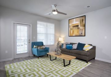 Fort Mill apartment for rent - A living room with a blue chair and a grey couch.