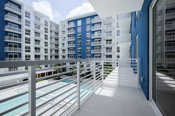 Miami apartment for rent - A modern building with a pool and a balcony.