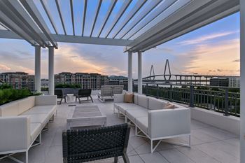 Expansive rooftop terrace with day beds and views of charleston harbor