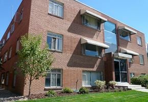 Denver apartment for rent - A red brick building with a tree in front.