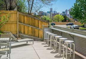 Denver apartment for rent - A row of white stools are lined up on a patio.
