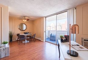 Denver apartment for rent - A dining room with a table set for four and a view of the city outside the window.