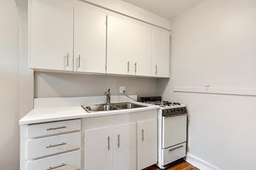 Denver apartment for rent - A white kitchen with a sink, stove, and cabinets.