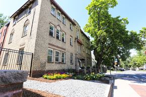 Denver apartment for rent - A building with a black fence and a gravel area in front.