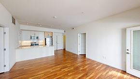 Englewood apartment for rent - A spacious room with wooden floors and white walls.