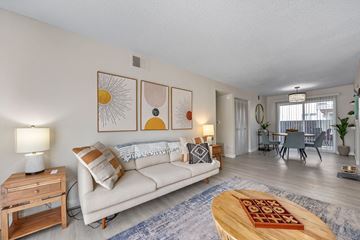 Windsor apartment for rent - A living room with a white couch, a wooden coffee table, and a painting on the wall.