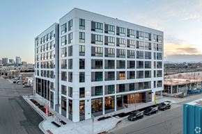 Denver apartment for rent - A modern building with a glass facade is shown in the image.
