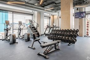 Denver apartment for rent - A gym with a variety of equipment including treadmills, stationary bikes, and weight racks.