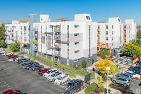 Denver apartment for rent - A parking lot with cars and apartment buildings in the background.