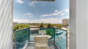 Englewood apartment for rent - A balcony with a table and chairs overlooking a cityscape.