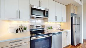 Englewood apartment for rent - A modern kitchen with white cabinets and stainless steel appliances.