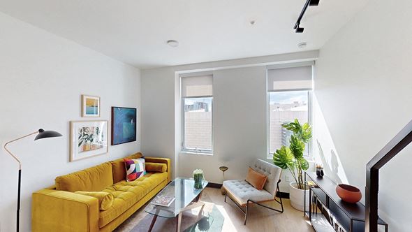 Denver apartment for rent - A living room with a yellow couch and a glass table.
