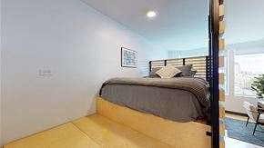 Denver apartment for rent - A bedroom with a bed, pillows, and a picture on the wall.