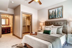 Denver apartment for rent - A bedroom with a large bed and a painting on the wall.