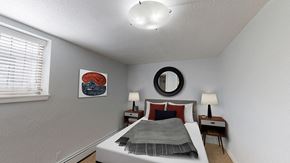 Denver apartment for rent - A bedroom with a bed, two nightstands, and a mirror.