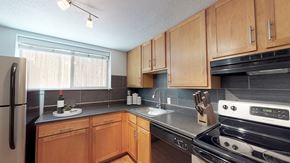 Denver apartment for rent - A kitchen with wooden cabinets and a black stove top oven.