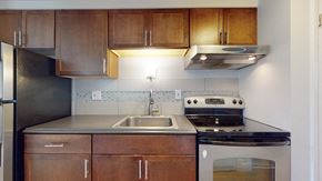 Denver apartment for rent - A kitchen with wooden cabinets and a stainless steel refrigerator.