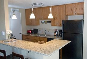 Denver apartment for rent - A kitchen with a granite counter top and wooden cabinets.