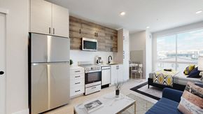 Denver apartment for rent - A modern kitchen with a stainless steel refrigerator and a wooden accent wall.