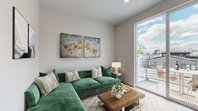 Denver apartment for rent - A living room with a green couch and a wooden coffee table.