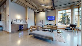 Denver apartment for rent - A spacious waiting room with a large couch and a flat screen TV mounted on the wall.