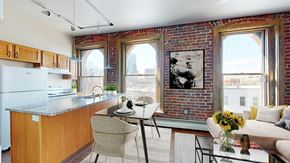 Denver apartment for rent - Open-plan kitchen with island,  dining table and living area with sofa. 3 large floor-to-ceiling windows look out on to the city landscape.