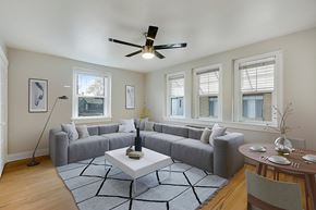 Denver apartment for rent - A living room with a grey couch, a white coffee table, and a ceiling fan.