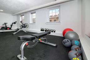 Denver apartment for rent - A gym room with a stationary bike, a rowing machine, and a set of dumbbells.