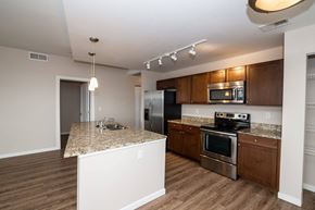 Denver apartment for rent - A kitchen with wooden cabinets and a granite countertop.