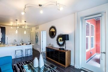 Denver apartment for rent - A modern living room with a blue chair and a glass table.