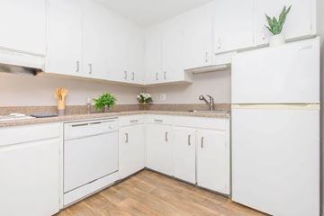 Denver apartment for rent - A kitchen with white cabinets and a white refrigerator.