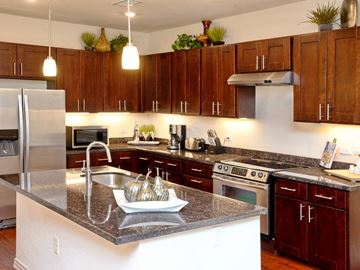 Englewood apartment for rent - A kitchen with brown cabinets and a granite countertop.
