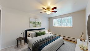 Lakewood apartment for rent - A bedroom with a bed, a ceiling fan, and a painting on the wall.