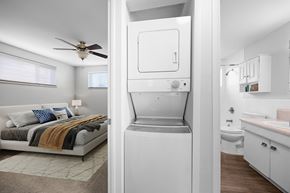 Lakewood apartment for rent - A white fridge is in the middle of a room with a bed and a bathroom.